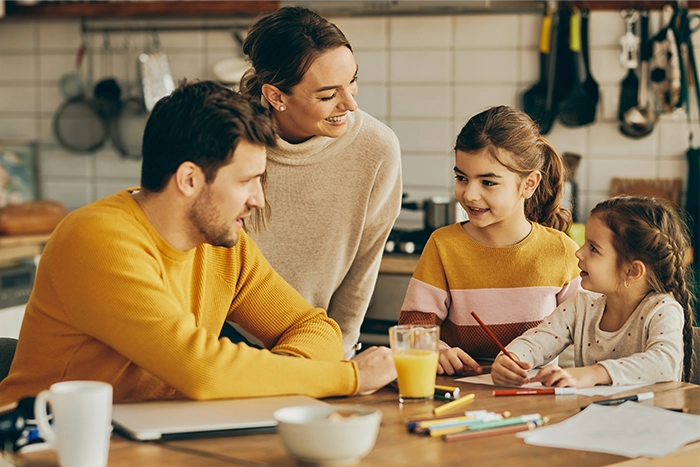 Eine Familie am Tisch. Die Kinder malen. 